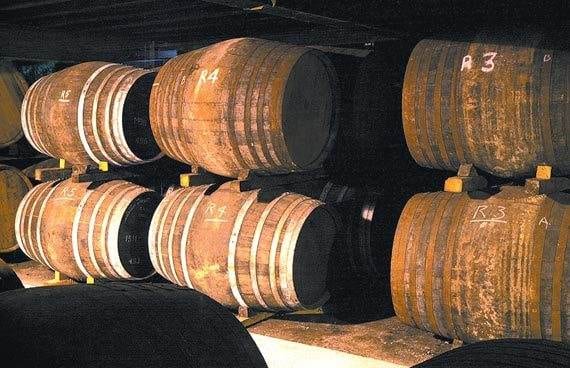 Many wooden barrels are lined up in a cellar, creating a pleasant ambiance for an evening with Ladybank.