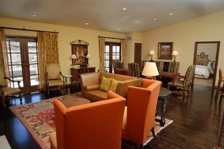 A living room with orange furniture and a fireplace in the hills of Napa Valley at the Meritage Resort and Spa.