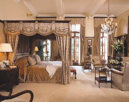 An ornate bedroom with a four poster bed featuring Victorian lifestyle at the modern Milestone Hotel.