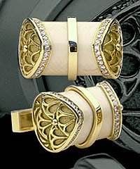 A pair of gold cufflinks with diamonds on them.