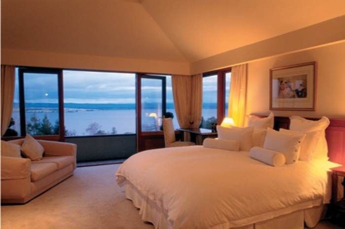 A bedroom with a large bed and a view of the ocean transformed into a paradise for guests.