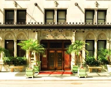 An ornate building with palm trees in front of it offering a great dining experience at Daniel.