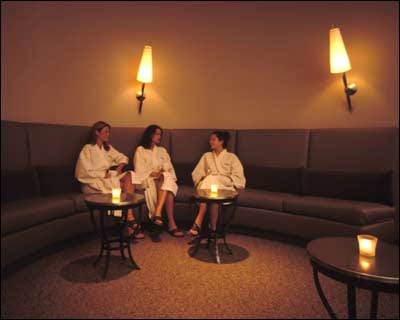 Three women enjoying a girlfriend getaway in NYC, indulging in spa treatments while surrounded by candles.