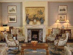 An ornately decorated living room with a fireplace, fit for royalty at the Presidential Suite of The Observatory Hotel.