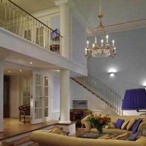 Experience the style of Austrian Duke in a large living room with a staircase at Palais Coburg Residenz.