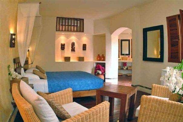 A bedroom with wicker chairs and a bed at Las Ventanas al Paraíso, showcasing a majestic view of the confluence of the sea and the ocean.