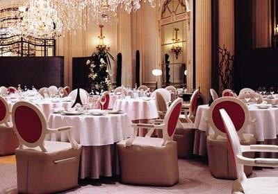 A large dining room with luxurious white tables and chairs.