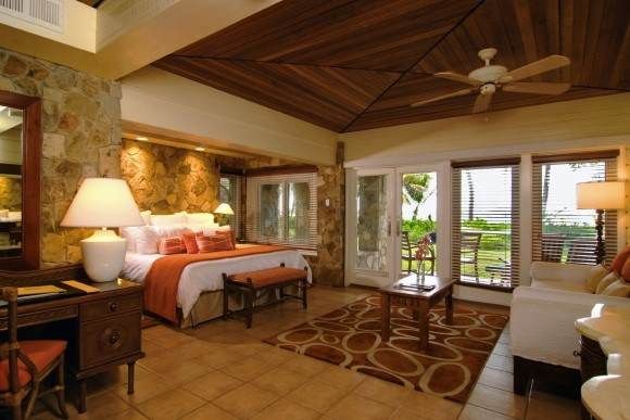 A room with a bed, a sofa, and a fireplace at Peter Island Resort.