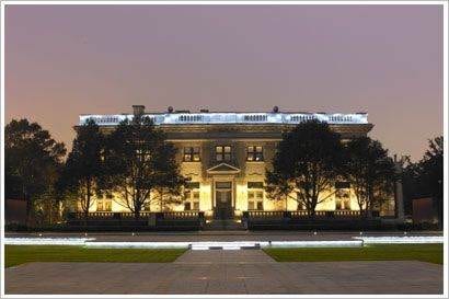 A grand mansion illuminated at night.