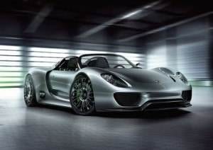 The Porsche 918 Spyder is showcased in a dimly lit room.