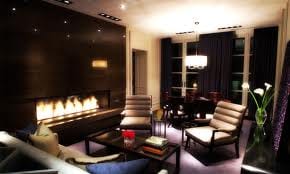 The Presidential Suite at Hazelton Hotel is a living room with a fireplace and couches.