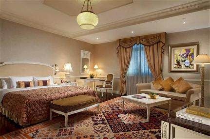 Experience the French style at Raffles Beijing Hotel in China with a large bed and a large rug.
