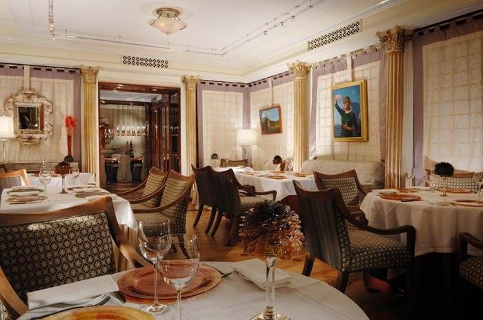 Vivendo- a restaurant at St. Regis, Rome with an ornate dining room equipped with tables and chairs.