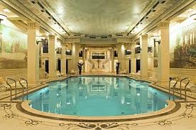 An ornate building featuring an indoor swimming pool that allows you to go back in time and live life king-size.
