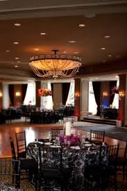 A large ballroom with black and white tables and chairs in Hotel Zaza-Dallas.