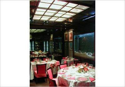 A dining room with a fish tank in the middle, enjoy Roman Dining at Alberto Ciarla.