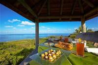 A table with food and drinks overlooking the ocean on Frégate Island Private.