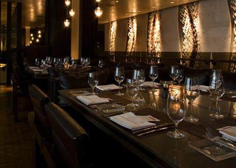 Savor the sumptuous dining experience at Se San Diego Hotel's elegant dining room with a long table and chairs.