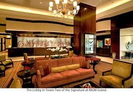 The lobby of The Signature at MGM Grand in Las Vegas with couches and a chandelier.