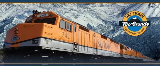 A train traveling through the mountains with mountains in the background.