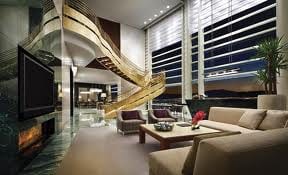 A living room with a fireplace and a spiral staircase, showcasing the exotic skyline of Las Vegas!