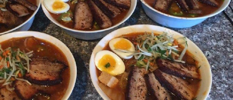 Four bowls of soup with meat and eggs prepared by MD chef.
