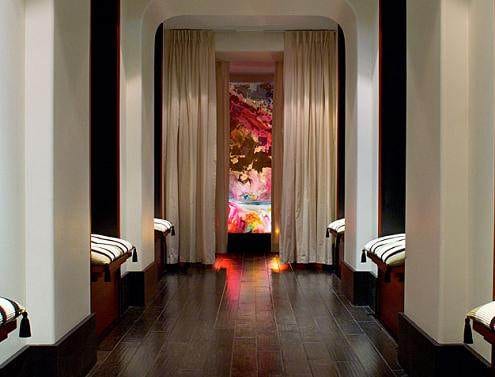 A long hallway with luxurious benches and a captivating painting.