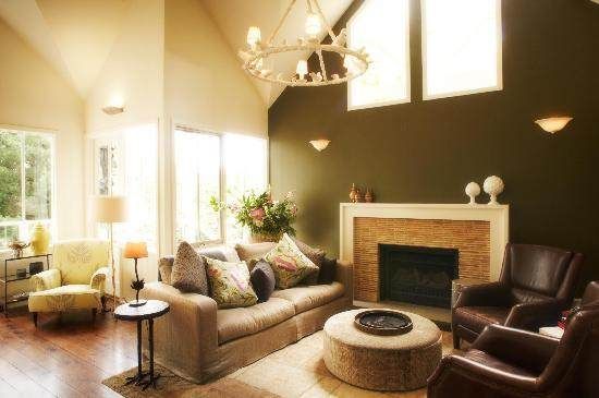 A living room with brown walls and a chandelier, perfect for a cozy stay.