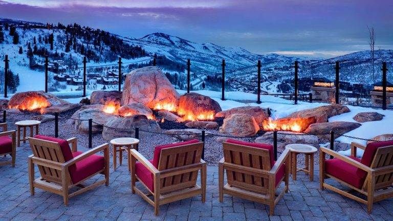 A fire pit sits in the middle of a snowy mountain at St. Regis Deer Valley in Utah, pampering guests with natural beauty amidst interior luxury.