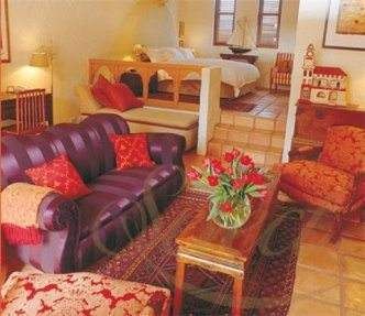 A living room with historical purple furniture and a fireplace for a royal accommodation at Tower Lodge.