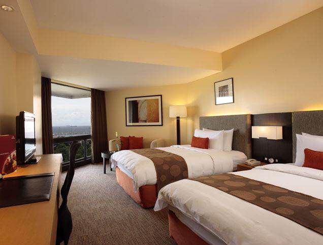 A hotel room with two beds and a television in Manila Bay.