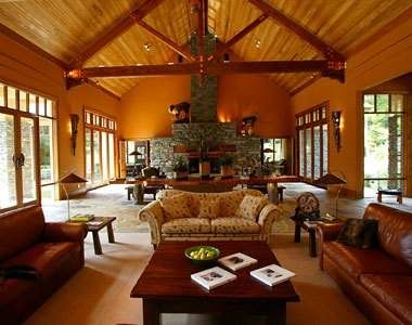 Treetops Lodge and Estate in Rotorua offers a large living room with couches and a fireplace.