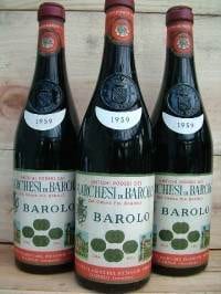 Three bottles of barolos sitting on a wooden table, celebrate with Marchesi di Barolo.