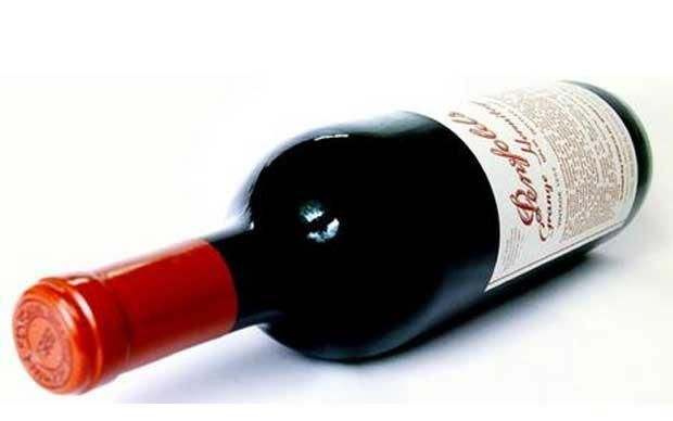 A bottle of a 1951 Penfolds Granje red wine on a white background.
