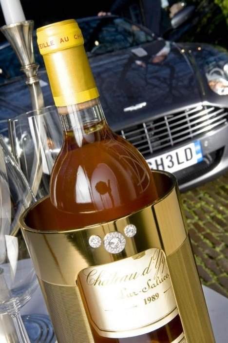 A bottle of Diamond studded La-Fraicheur wine cooler is sitting on a table next to a car.