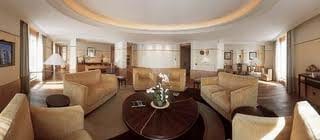 A luxurious living room with couches and a coffee table at The Peninsula Suite in Bangkok.