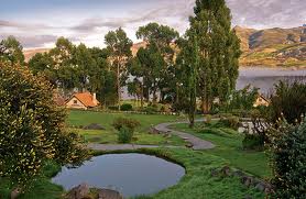 A tranquil pond surrounded by trees and a house.