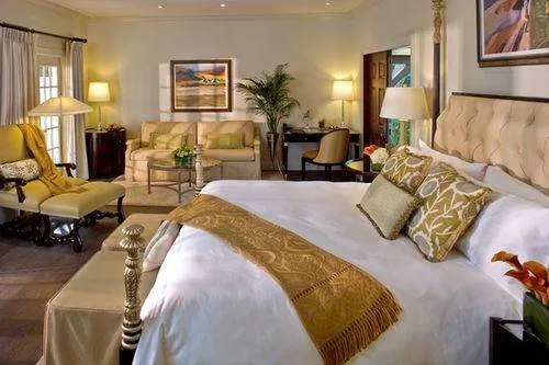 A bedroom with a large bed and chairs, just a short ferry ride to the magnificent Fisher Island Hotel and Resort.
