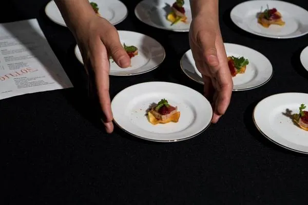 A person is holding plates of food at a stellar event on Treasure Island.