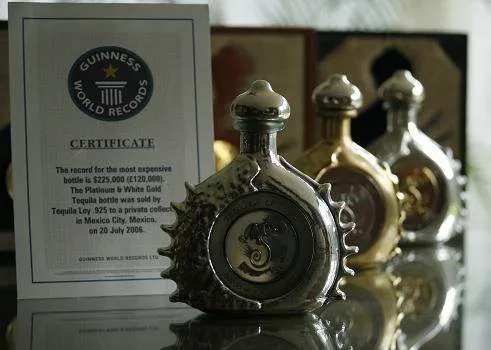 A bottle of Passion Azteca tequila sits on a table next to a certificate, embodying royalty.