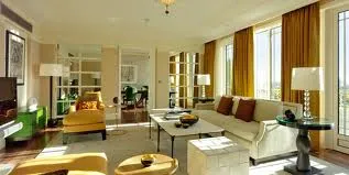 Harlequin Suite - a luxury destination in London with large windows and yellow furniture.