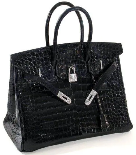 A black crocodile skin handbag with diamonds on a white background.