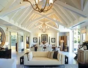 Feel the natural riverside lifestyle at The Huka Lodge, a large living room with white furniture.