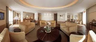 A luxurious living room with couches and a coffee table at The Peninsula Suite in Bangkok.