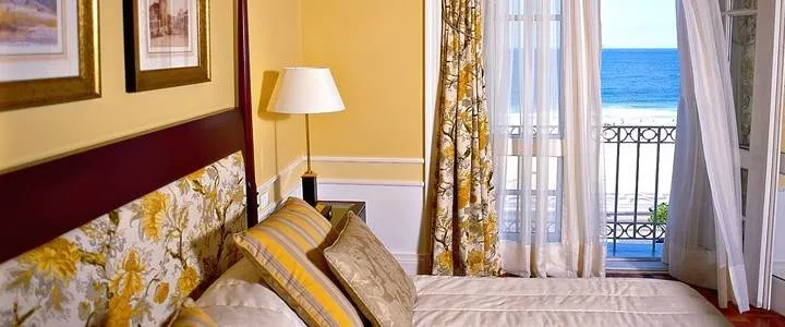 A luxurious bedroom with a balcony overlooking the ocean at the Copacabana Palace.