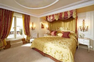 Feel the legendary luxury at Hotel de Crillon in Paris, featuring a large bedroom with a gold canopy bed.