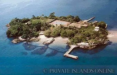 A small island paradise with a dock in the ocean.