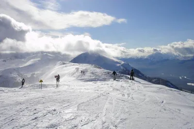 A group of people skiing on a snow covered mountain at a family-friendly ski resort in the Canadian Rockies.