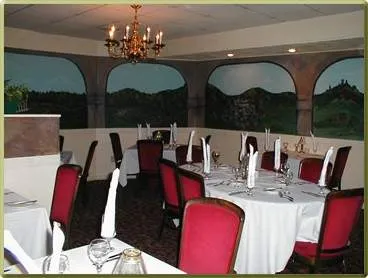 A dining room with red chairs and a mural on the wall at Barresi's Italian Restaurant in Cincinnati.
