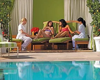 A group of Glam-Girls relaxing around a pool on their Beverly Hills getaway.